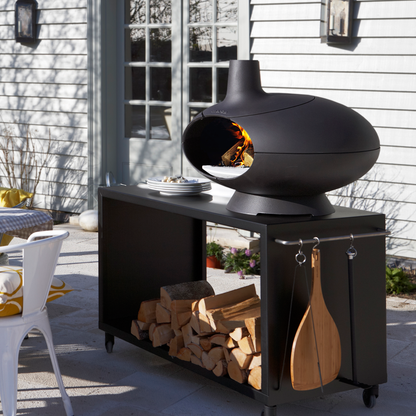 Morso Forno Garden ensemble sur la terrasse avec le four Forno allumé. Quelques bûches de bois sur la pierre à pizza et la température monte dans le four Forno.